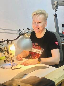 Właścicielka pracowni krawieckiej Marzena Dyksińska projektuje przy biurku