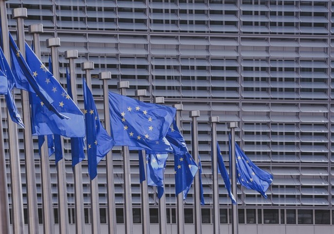 Flagi unijne przed budynkiem Parlamentu Europejskiego